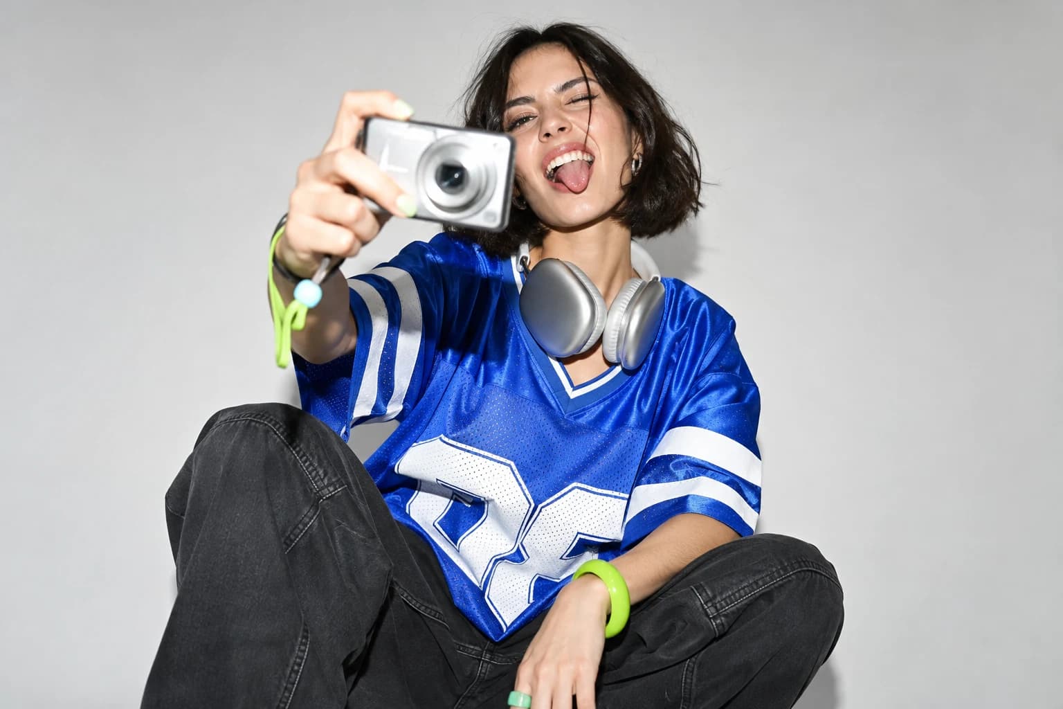 A creator in a cobalt blue jersey capturing a moment with her camera